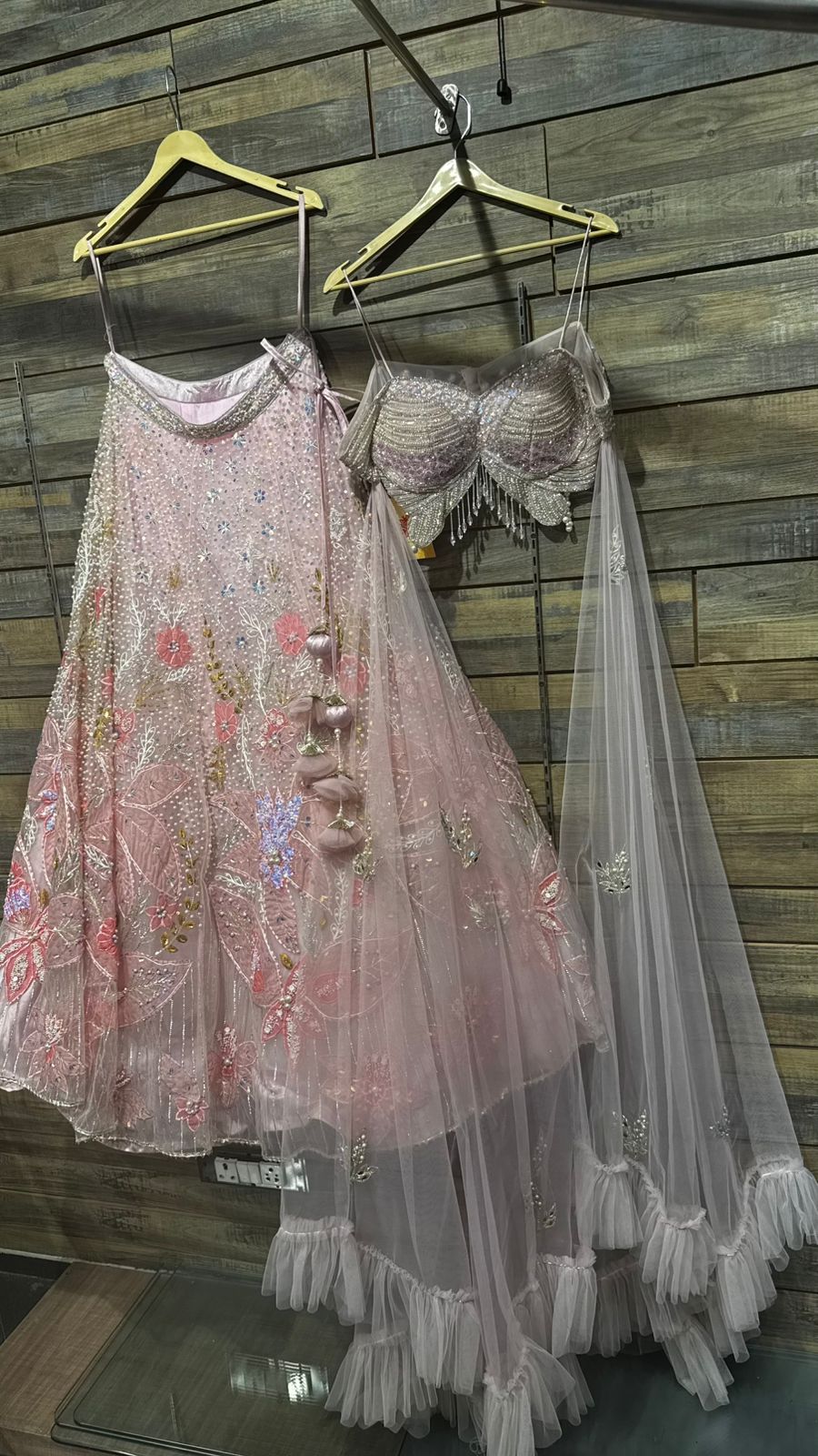 Imported Net Powder Pink Lehenga with beautiful handwork in pearl and beads teamed with full handwork blouse with tassels and dropping dupatta coming from behind the top for amazingly angelic appeal
