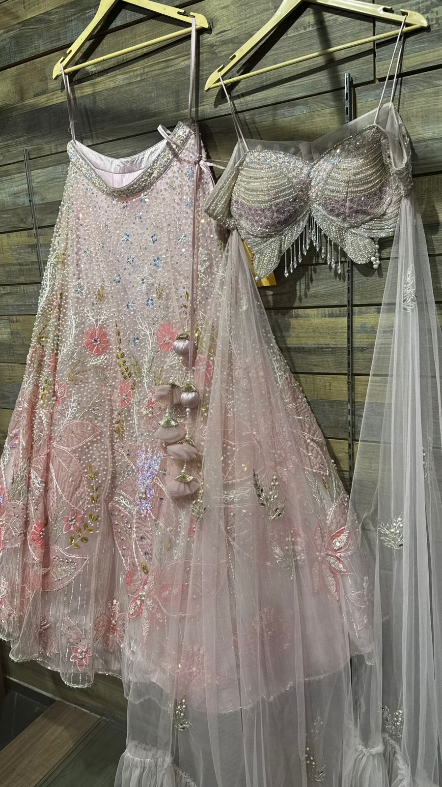 Imported Net Powder Pink Lehenga with beautiful handwork in pearl and beads teamed with full handwork blouse with tassels and dropping dupatta coming from behind the top for amazingly angelic appeal