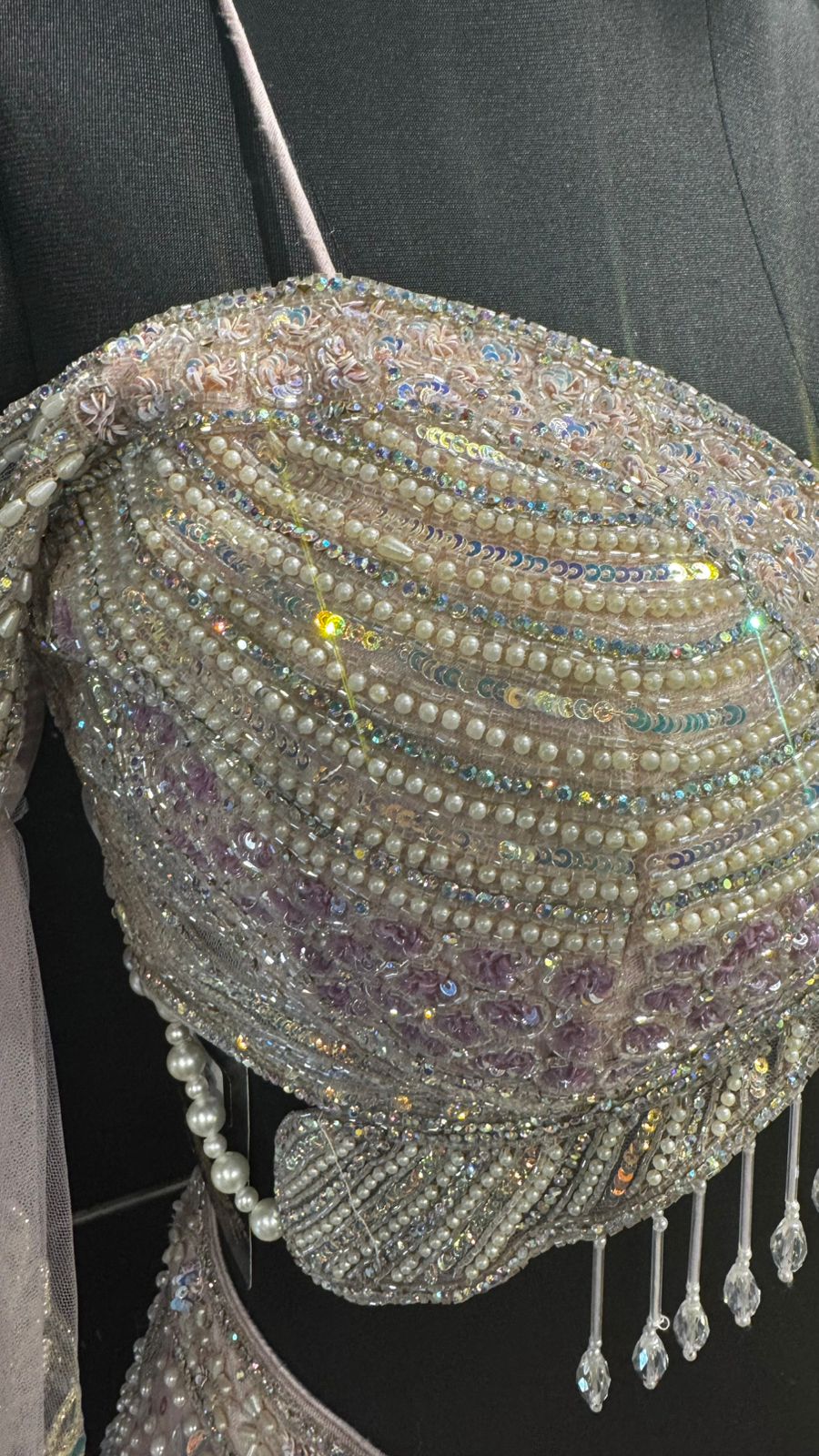 Imported Net Powder Pink Lehenga with beautiful handwork in pearl and beads teamed with full handwork blouse with tassels and dropping dupatta coming from behind the top for amazingly angelic appeal