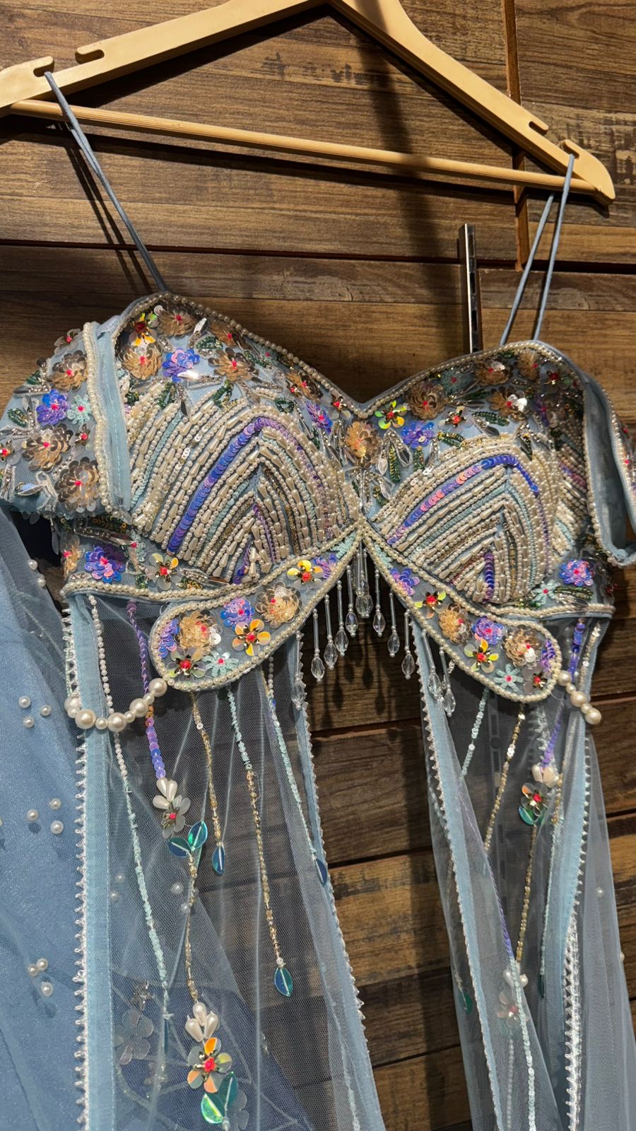 Imported Net Powder Blue Lehenga with beautiful handwork in pearl and appliqué teamed with full handwork blouse in beads with dropping shoulders along with two panels doing down to brighten up your ceremonial affairs