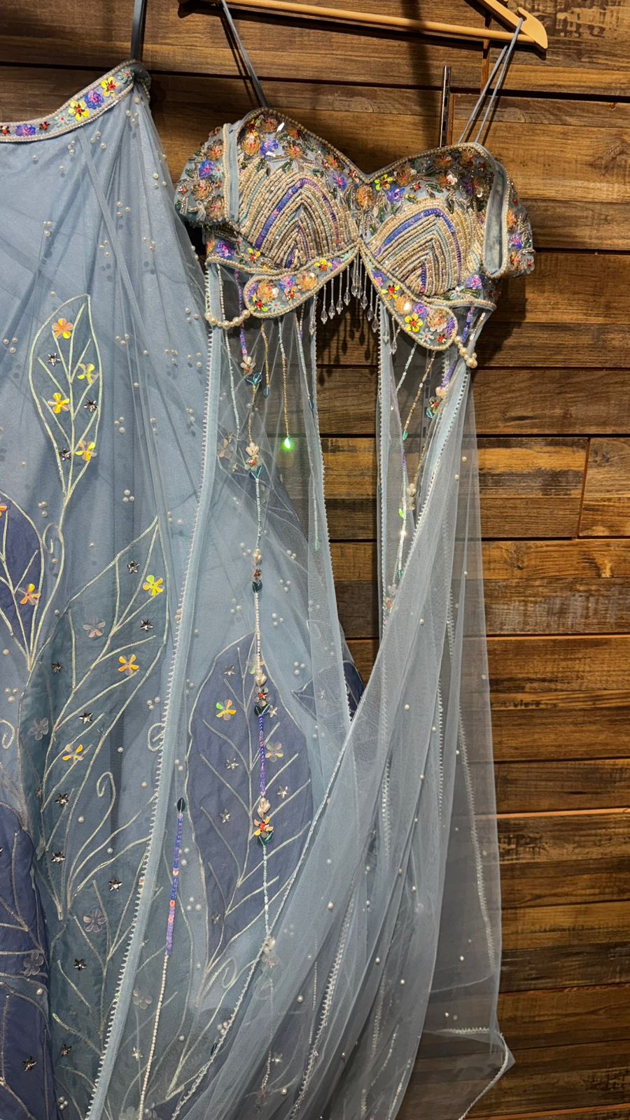 Imported Net Powder Blue Lehenga with beautiful handwork in pearl and appliqué teamed with full handwork blouse in beads with dropping shoulders along with two panels doing down to brighten up your ceremonial affairs