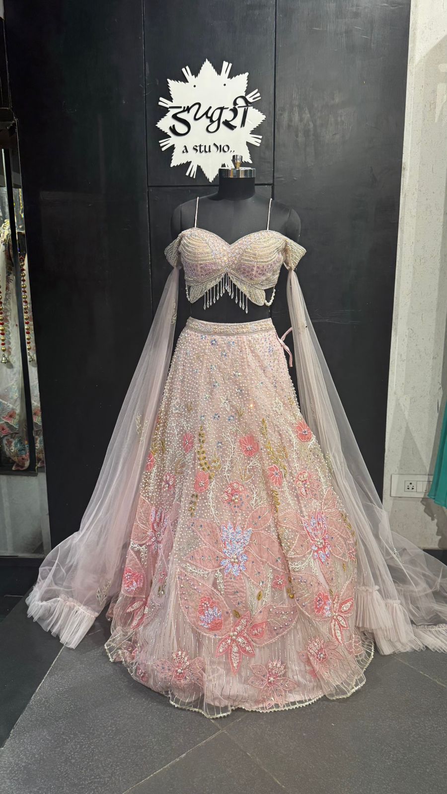 Imported Net Powder Pink Lehenga with beautiful handwork in pearl and beads teamed with full handwork blouse with tassels and dropping dupatta coming from behind the top for amazingly angelic appeal