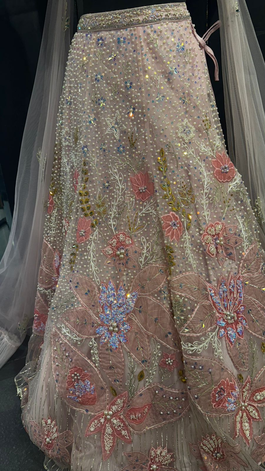 Imported Net Powder Pink Lehenga with beautiful handwork in pearl and beads teamed with full handwork blouse with tassels and dropping dupatta coming from behind the top for amazingly angelic appeal